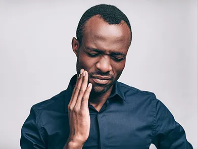 A person holding their jaw, indicating dental discomfort.